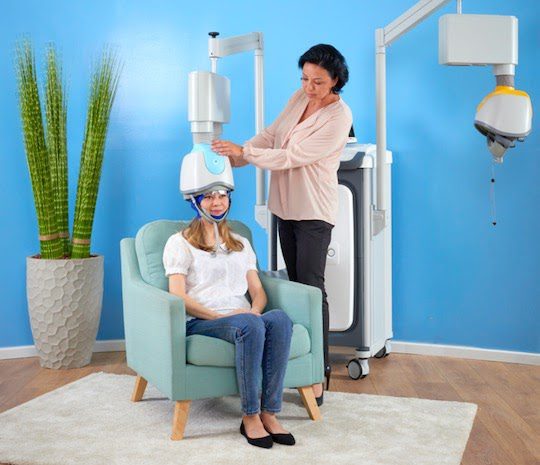 Therapist adjusting the BrainsWay deep TMS helmet on a patient