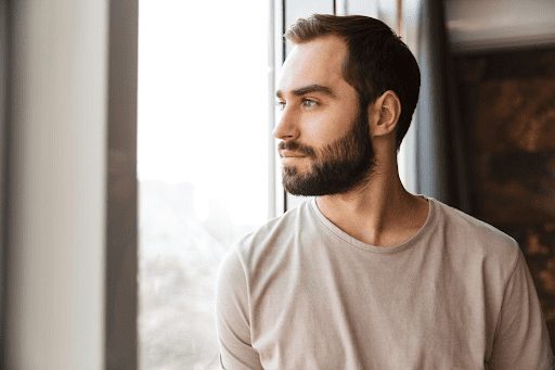 Anxious man looking on a window