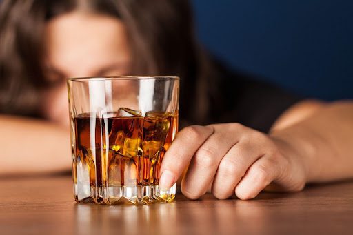 Depressed woman with alcohol