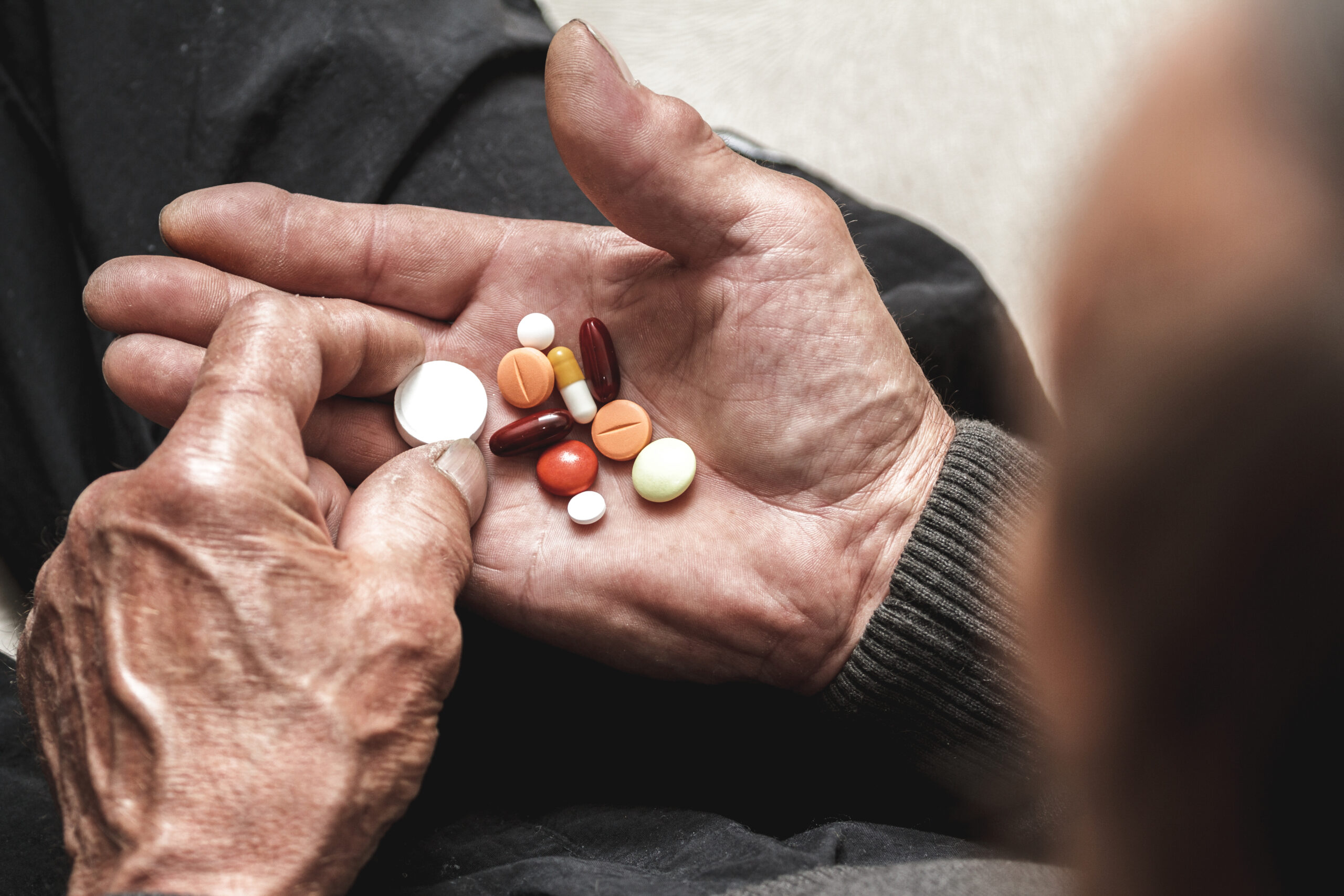 elderly person holding pills